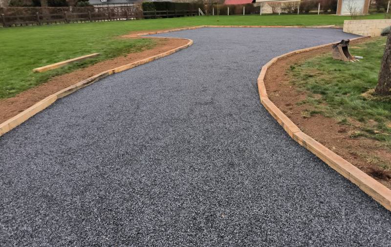 Travaux de terrassement et aménagement d'un parking et d'une allée en graviers gris, avec contours bois, pour une maison à Saint-Romain-de-Colbosc